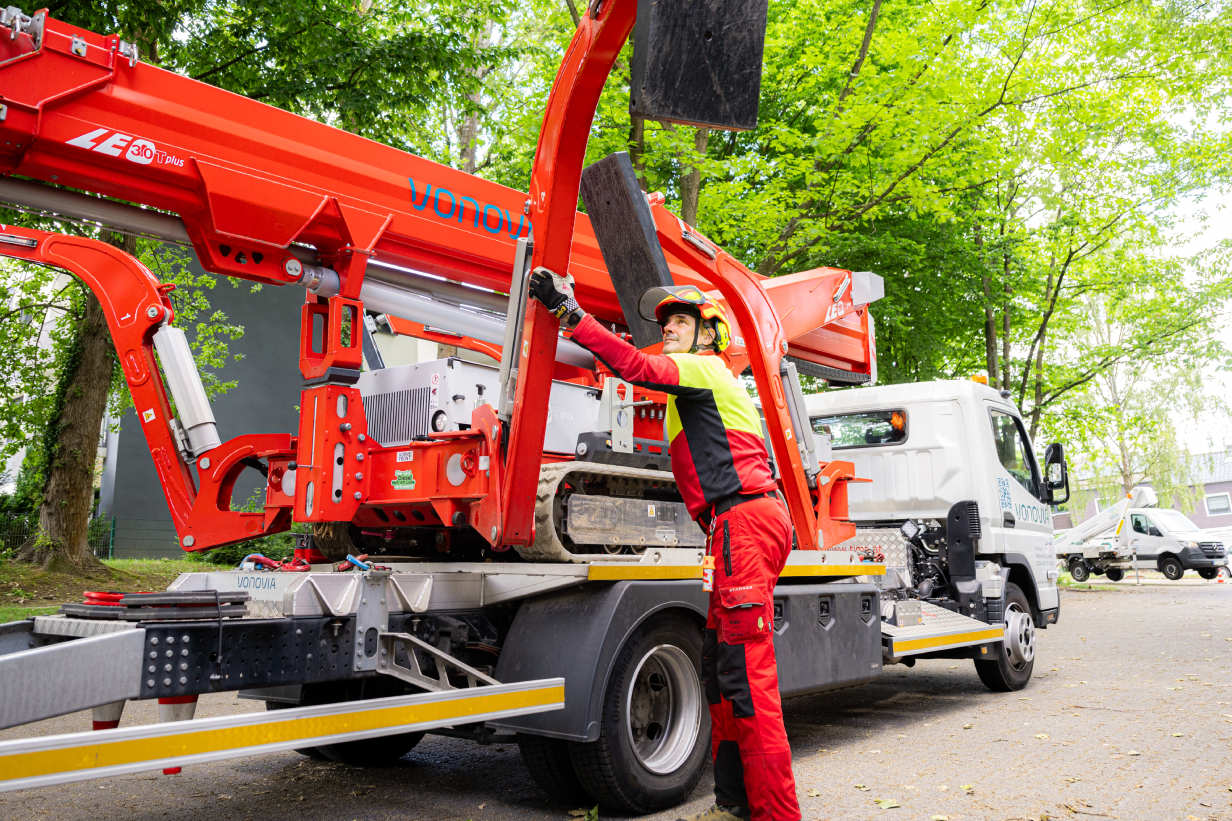 Baummanagement-Mitarbeiter vor einem Kranfahrzeug. Baummanagement-Mitarbeiter vor einem Kranfahrzeug.