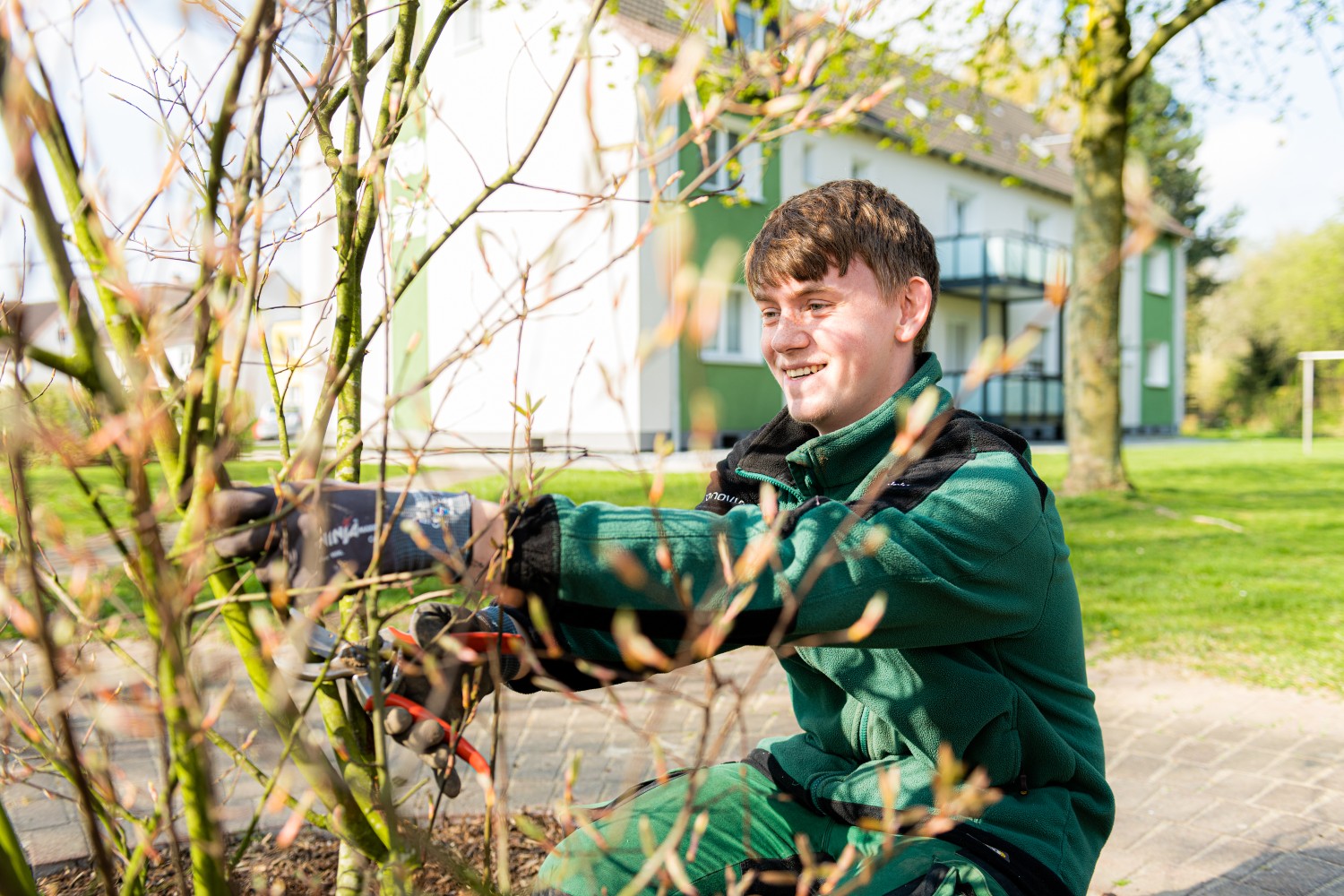 Azubi in Vonovia Arbeitskleidung bei der Grünpflege. Azubi in Vonovia Arbeitskleidung bei der Grünpflege.