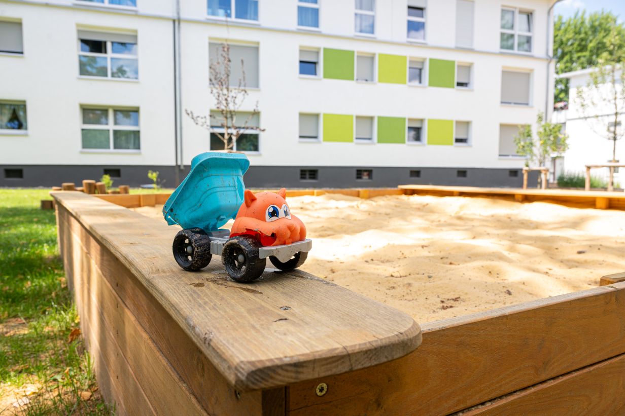 Gepflegter Sandkasten mit Sandspielzeug dank Spielplatzwartung.